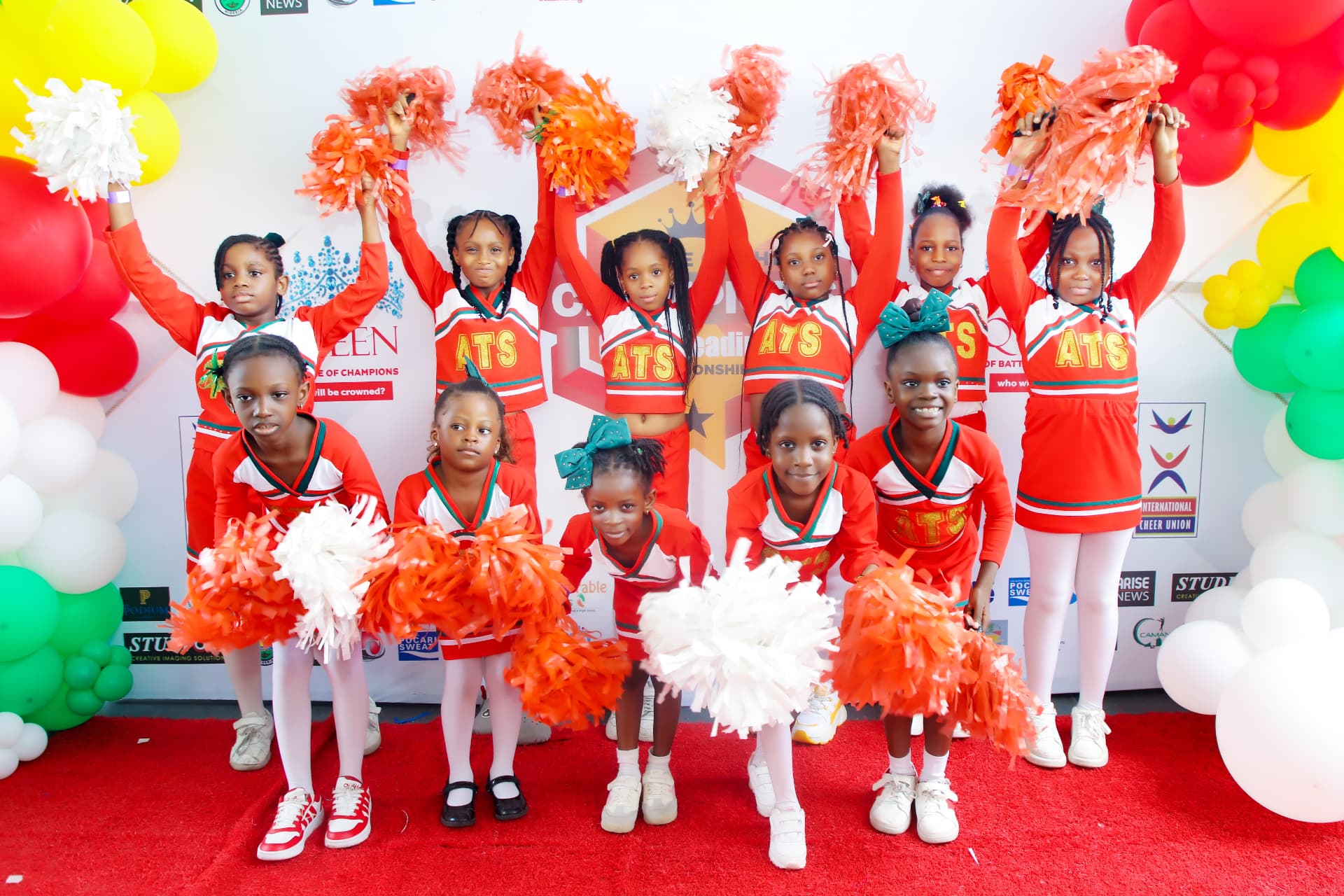 A cheerleading team posing with red and white pom-poms
