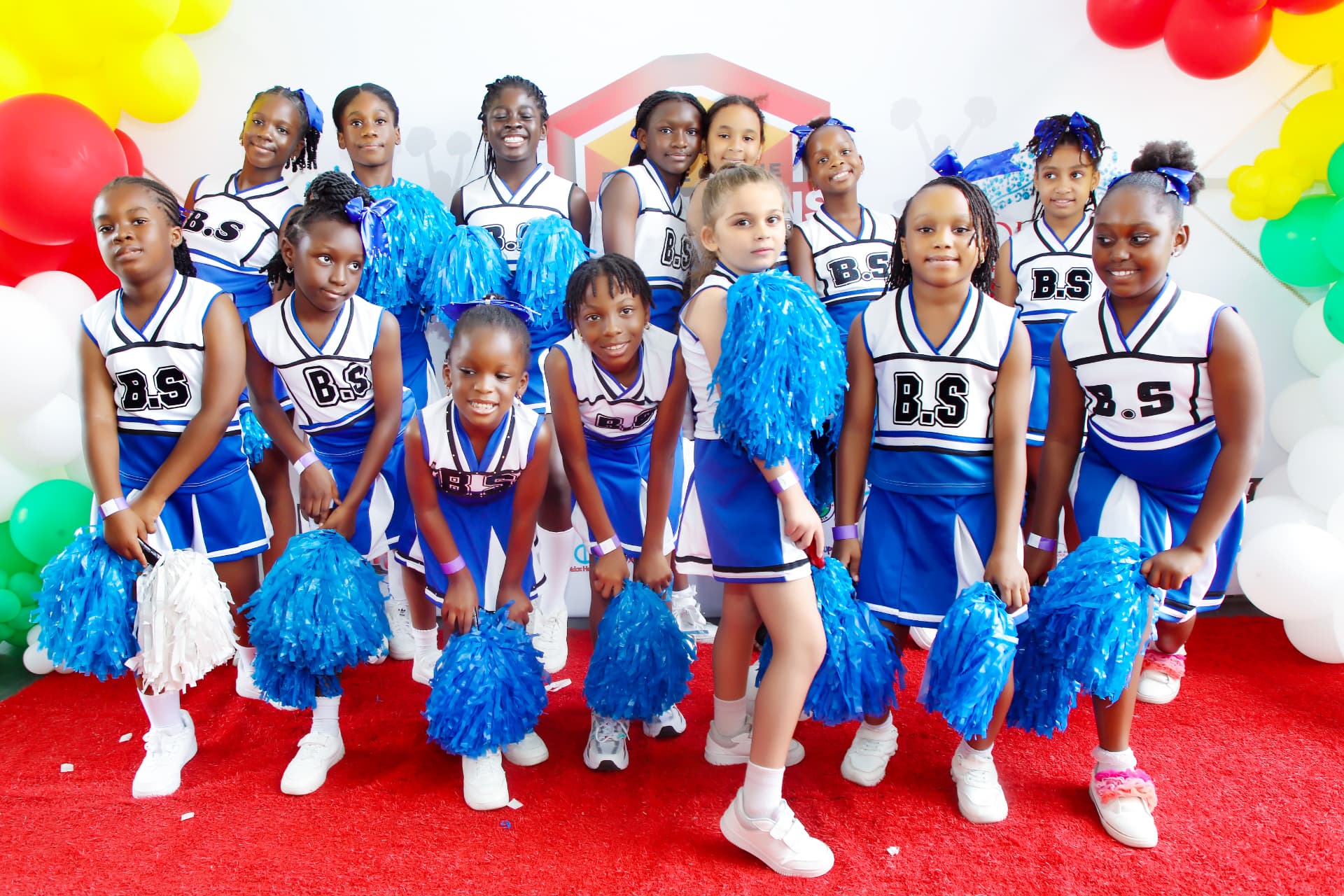 A cheerleading team in blue and white uniforms posing with blue pom-poms