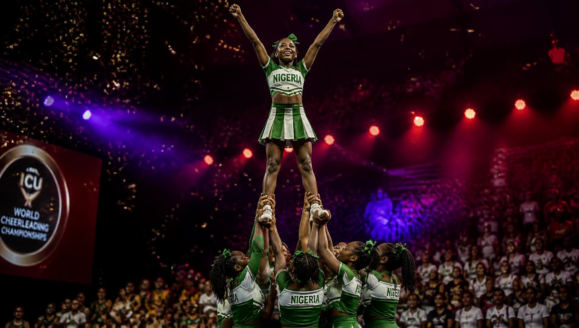 Cheerleaders performing a stunt under arena lighting at the Battle of the Champions